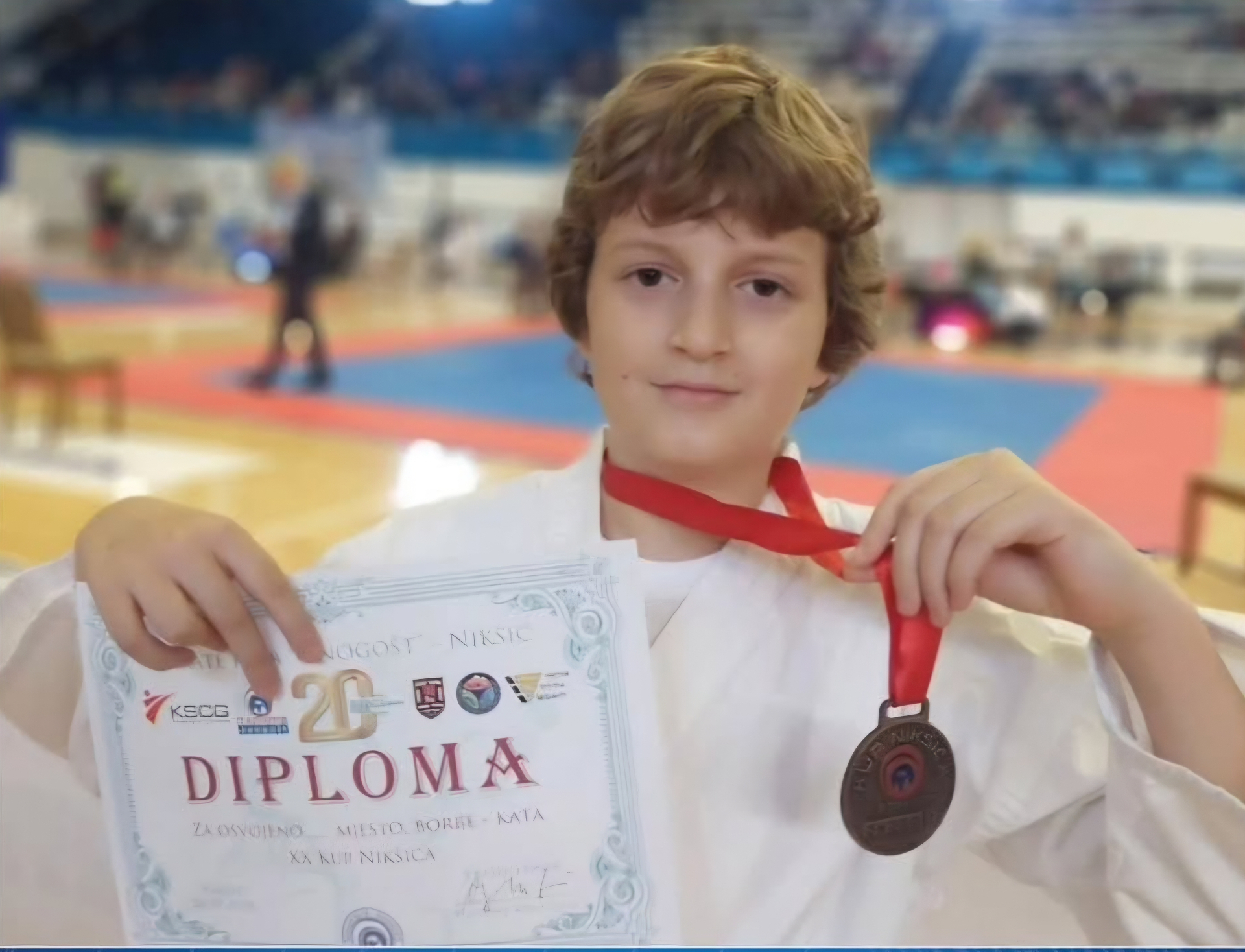 Mladi takmičar pokazuje diplomu i medalju